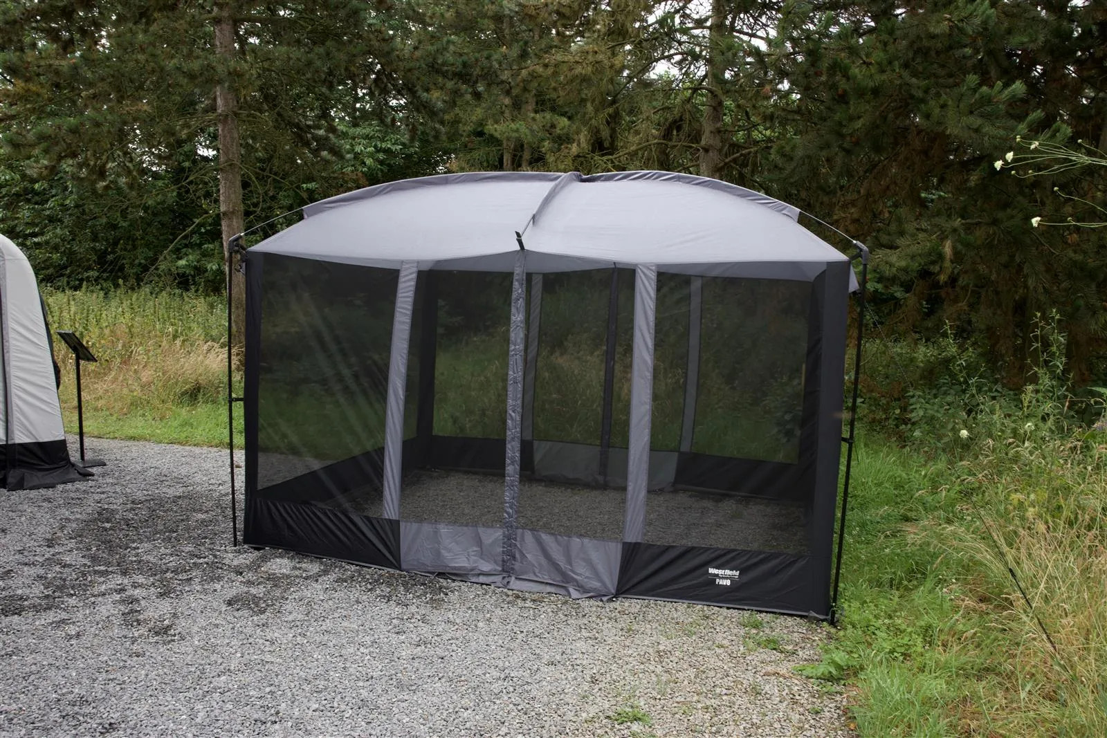 Freistehender Camping Pavillon Westfield Pavo mit umlaufendem Moskitonetz im Außenbereich aufgebaut