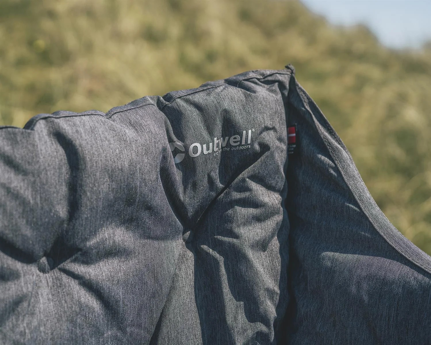 Nah am Polster ist das Outwell Sardis Lake Sofa mit Logo auf dem grauen Stoffbezug zu sehen.