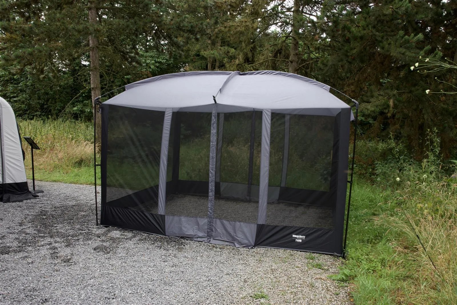 Freistehender Camping Pavillon Westfield Pavo mit umlaufendem Moskitonetz im Außenbereich aufgebaut
