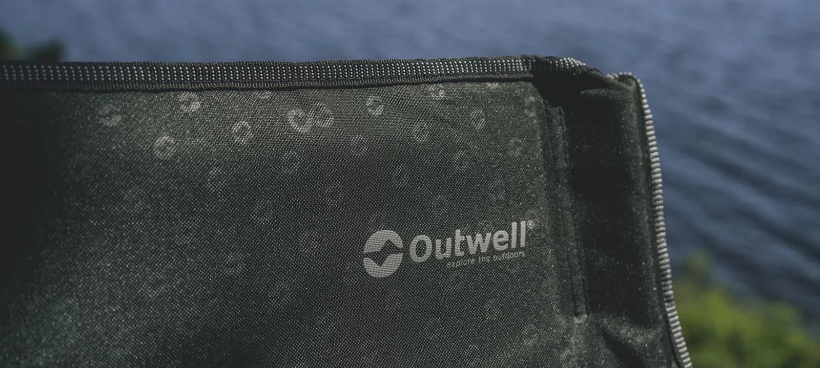 Auf der Rueckseite des Outwell Goya ist das Markenlogo auf dem dunklen Stoff mit umlaufendem Reissverschluss zu sehen.