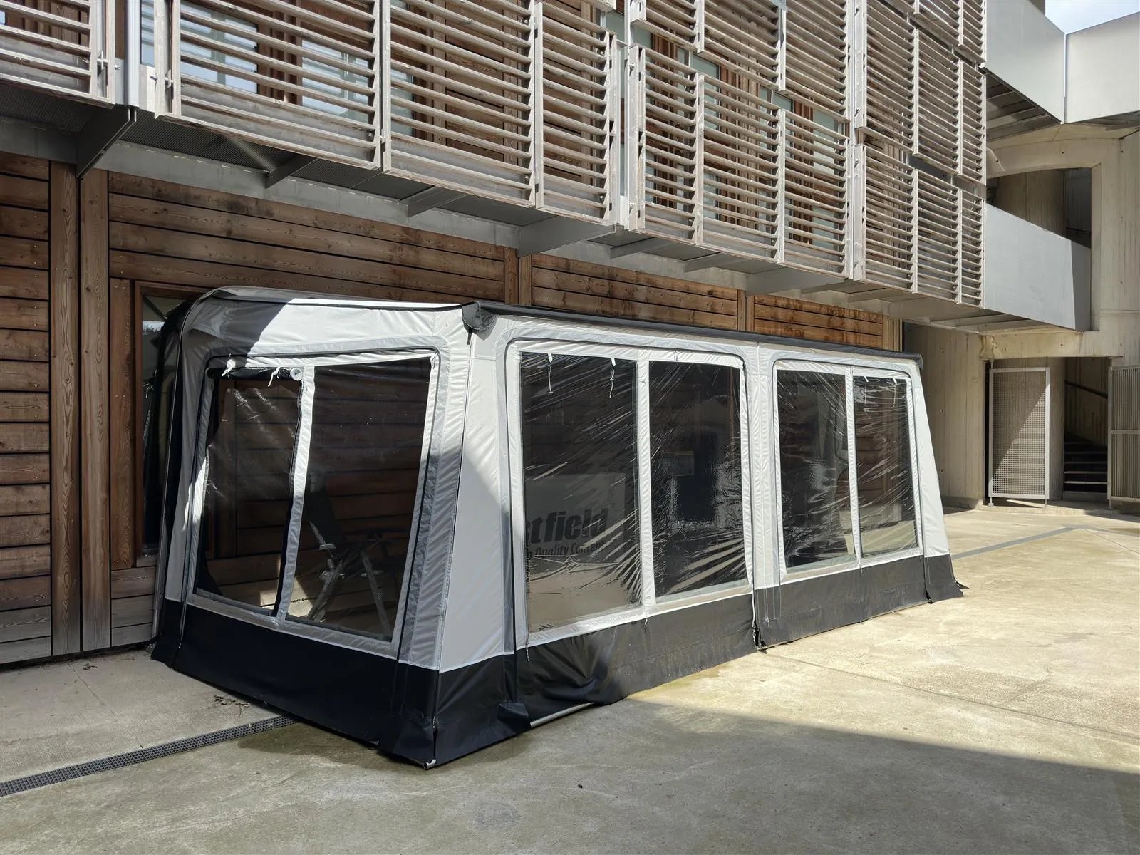 Schräg aufgebautes Westfield Luna Plus 11 Markisenzelt mit Seitenwand und großen Fensterflächen