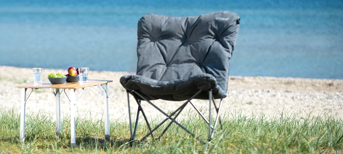 Am Strand ergänzt der Outwell Fremont Lake Stuhl den kleinen Campingtisch und schafft einen gemütlichen Platz mit Blick aufs Wasser.