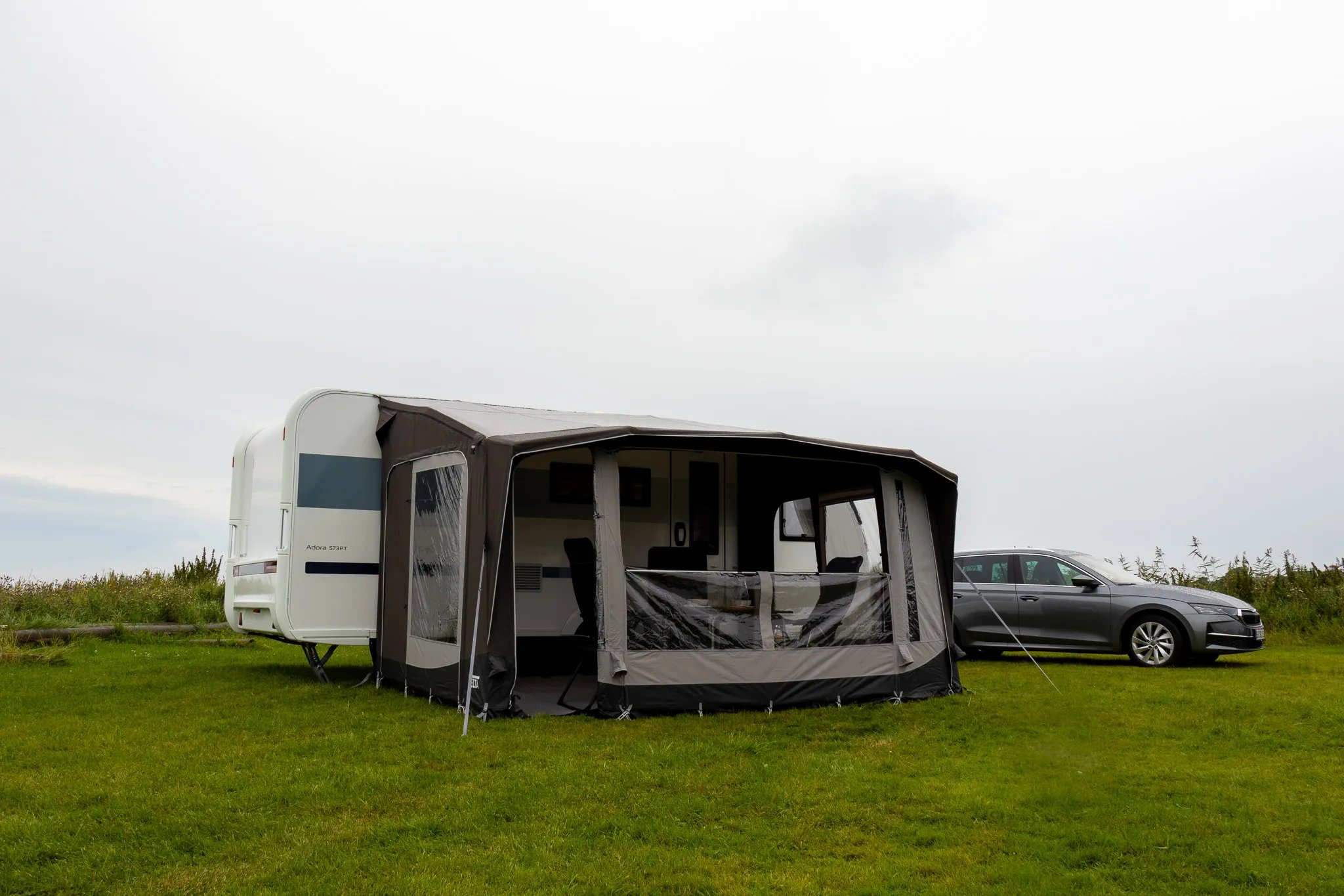 Geöffnete Front des Telta Scenic 390 Vorzelts mit Blick in den Innenraum am Wohnwagen