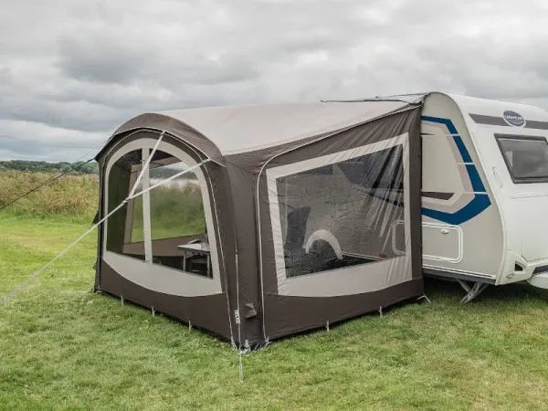 Telta Sky Link Vorzelt in Seitenansicht, aufgebaut und direkt am Wohnwagen angeschlossen mit großen Fensterflächen