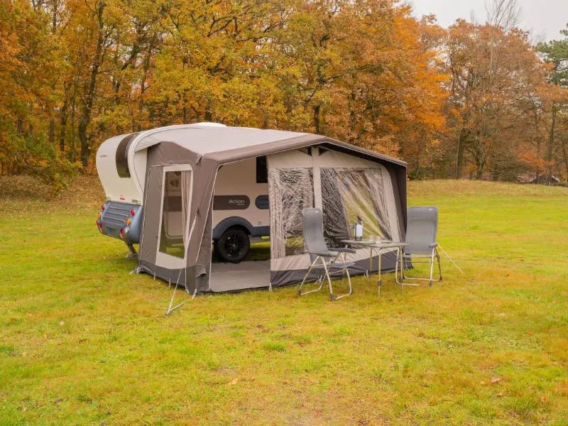 Telta Action 361/391 Wohnwagen Vorzelt mit Sitzgruppe vor dem Eingang auf herbstlicher Wiese aufgebaut