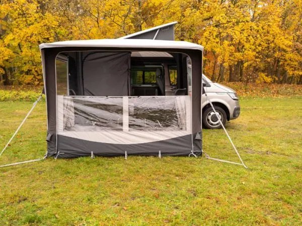 Telta Core 260 Busvorzelt mit geöffneter Front und halbtransparenter Panoramafläche vor einem Kastenwagen im Herbst