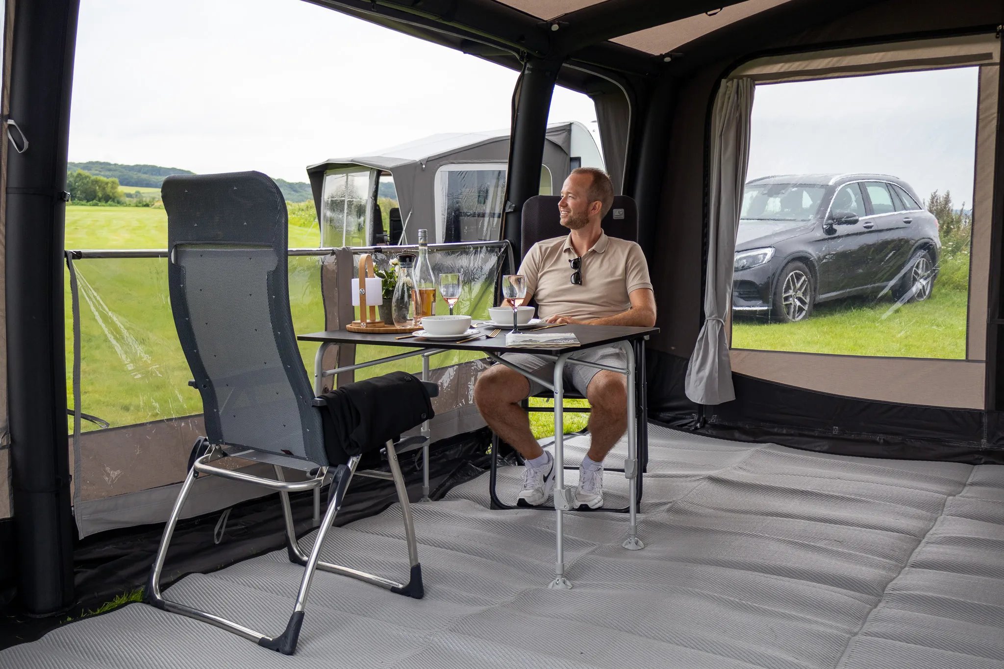 Essplatz im Telta Scenic 390 Vorzelt mit sitzender Person und gedecktem Tisch