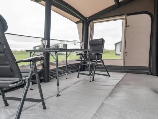 Innenansicht des Telta Core 390 Busvorzelts mit Tisch und Stühlen sowie großem Raumgefühl und Blick nach draußen