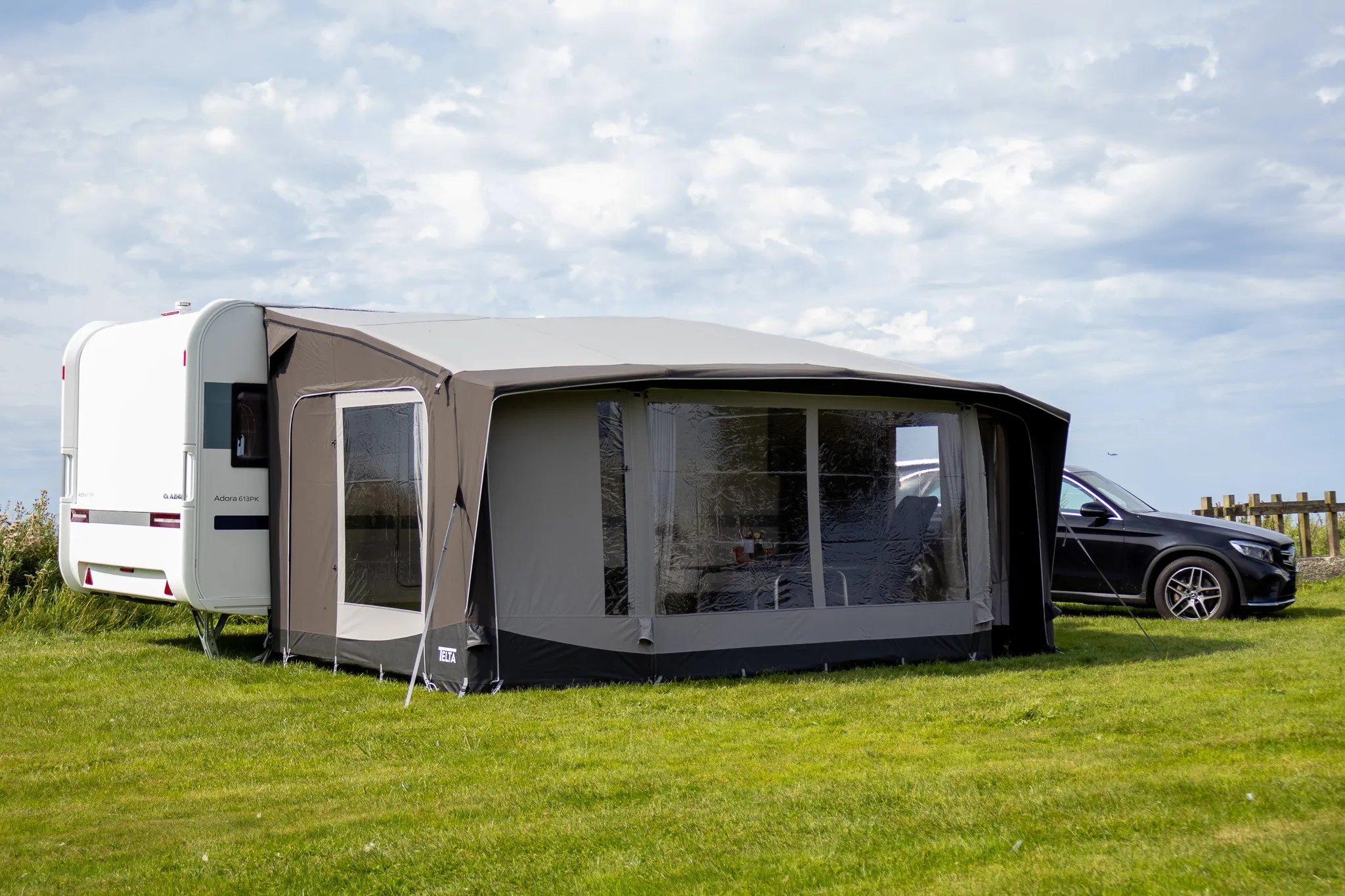 Telta Scenic 490 Vorzelt am Wohnwagen mit großen Panoramafenstern auf einer grünen Wiese