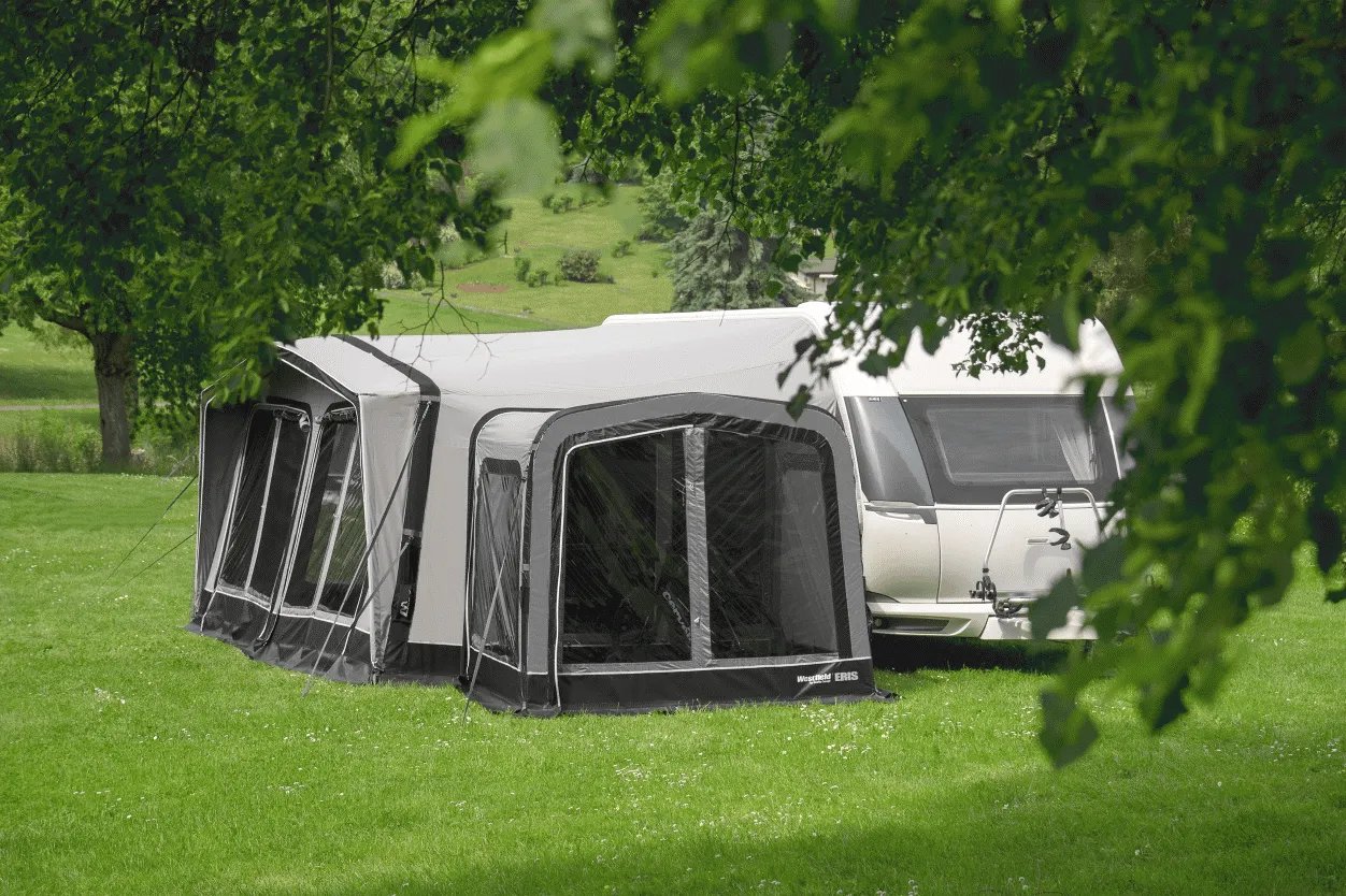 Westfield Eris Anbauzelt Modell 2023 seitlich am Wohnwagen aufgebaut auf einer Wiese mit großzügigen Fensterflächen und erweitertem Wohnraum