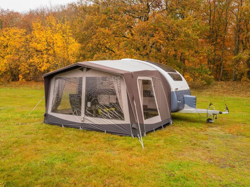 Frontansicht des Telta Action 361/391 Wohnwagen Vorzelts mit großen Panoramafenstern auf herbstlicher Wiese