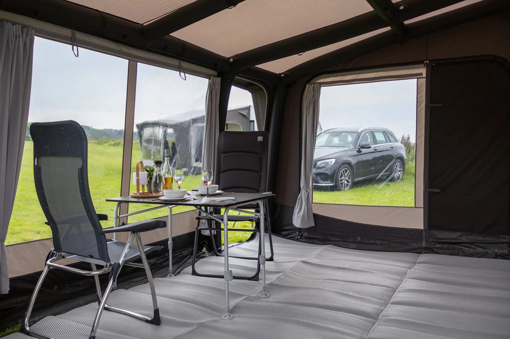 Sitzgruppe im Telta Scenic 390 Vorzelt mit großen Fenstern und gedecktem Tisch