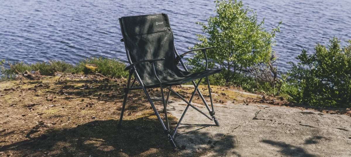 Am Ufer steht der Outwell Goya auf felsigem Boden und eignet sich als Campingstuhl fuer Pausen am Wasser.