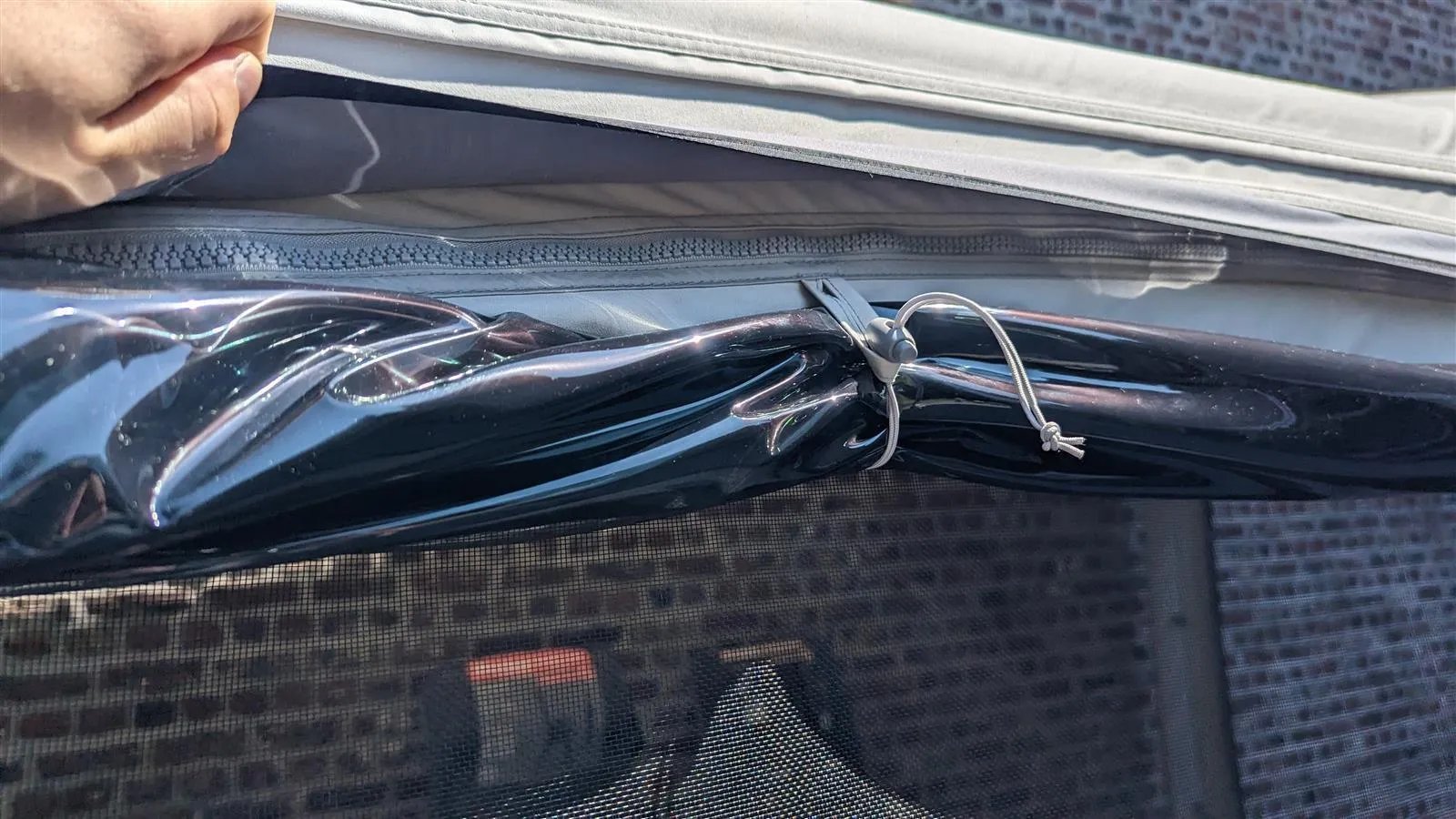 Aufgerollte Fensterfolie mit Fixierung und Moskitonetz am Vega 375 Luftvorzelt, Anbauhöhe 255–285 cm