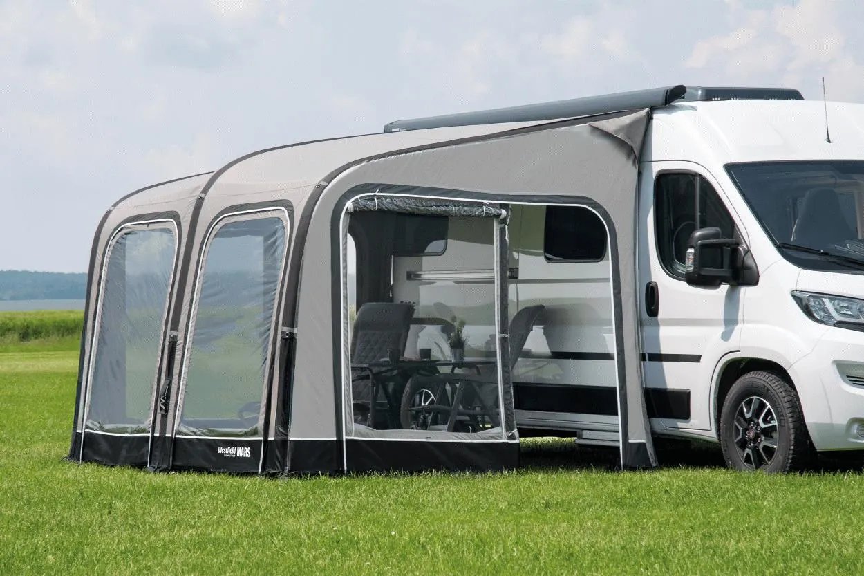 Westfield Mars Kastenwagen Vorzelt mit geöffnetem Eingang am Camper aufgebaut auf Wiese mit Blick in den Innenraum