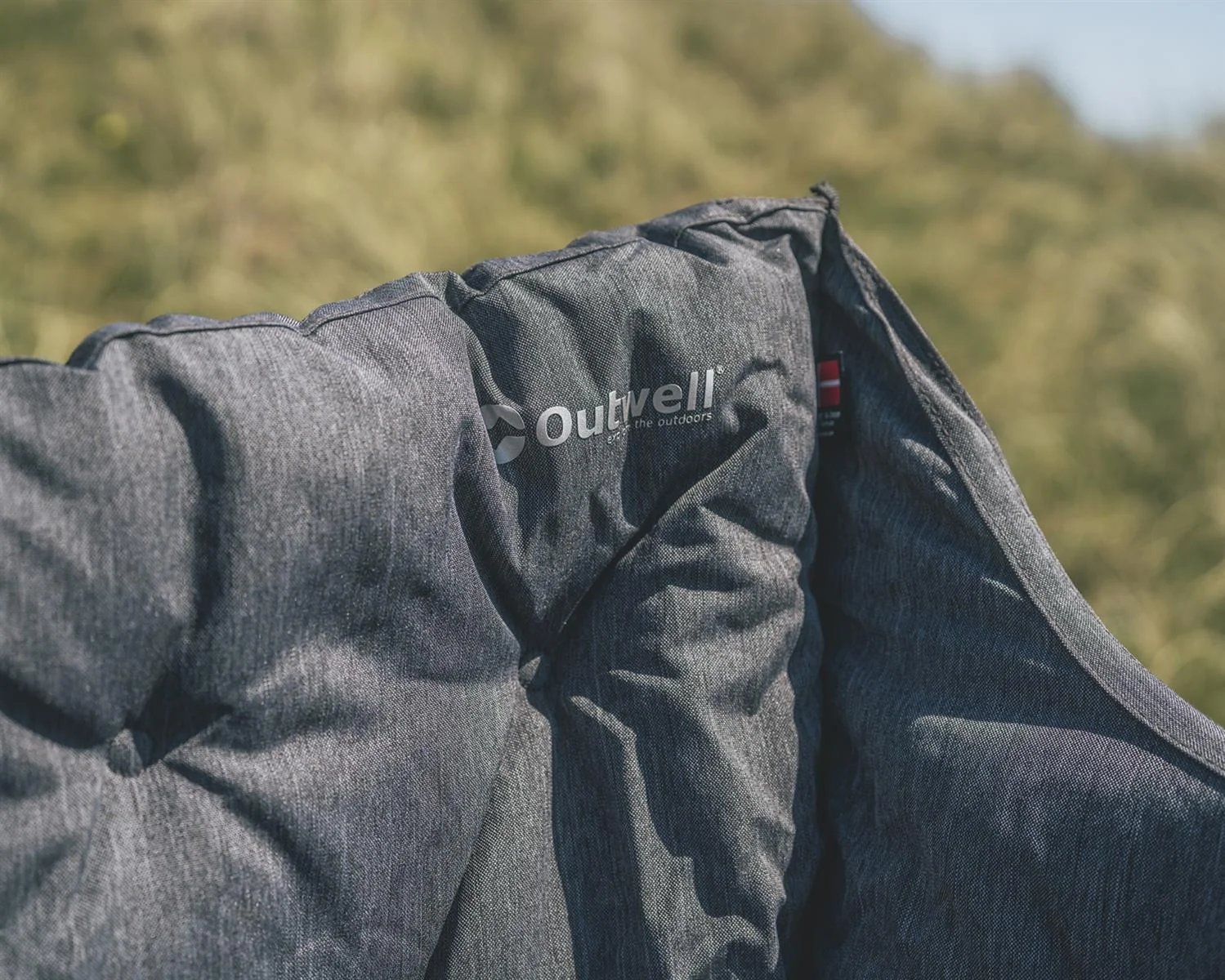 Nah am Polster ist das Outwell Sardis Lake Sofa mit Logo auf dem grauen Stoffbezug zu sehen.