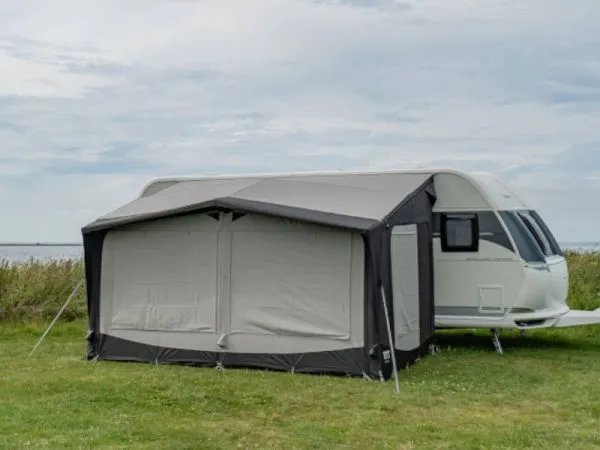 Rückansicht des Telta Estate 390 Vorzelts mit geschlossenen Fensterabdeckungen an einem Wohnwagen auf einer Wiese