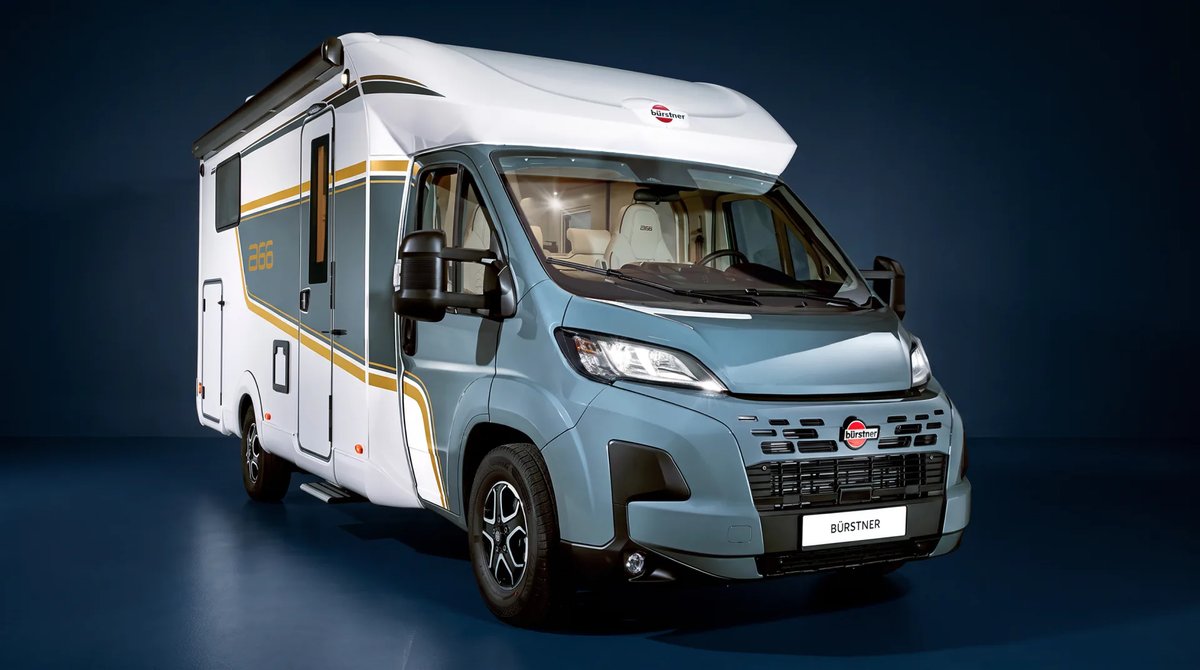 Bürstner B66 Wohnmobil, teilintegriert, allein im weiten Studioraum, blaugraues Fahrerhaus und weißer Aufbau, Dreiviertelansicht von vorn rechts vor tiefblauer Wand