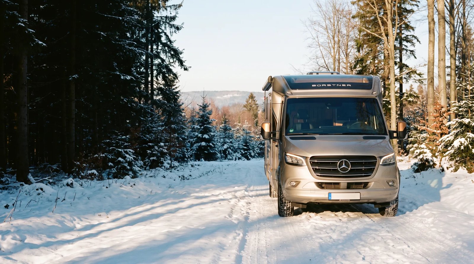 Bürstner Signature Mercedes auf einer Winterlichtung, Nachmittagslicht von rechts auf Fahrerhaus und Aufbau