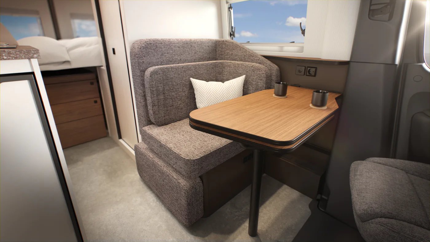 Sitzlounge im Bürstner Habiton mit grau meliertem Polster, Holztisch und freiem Durchgang zum Heck