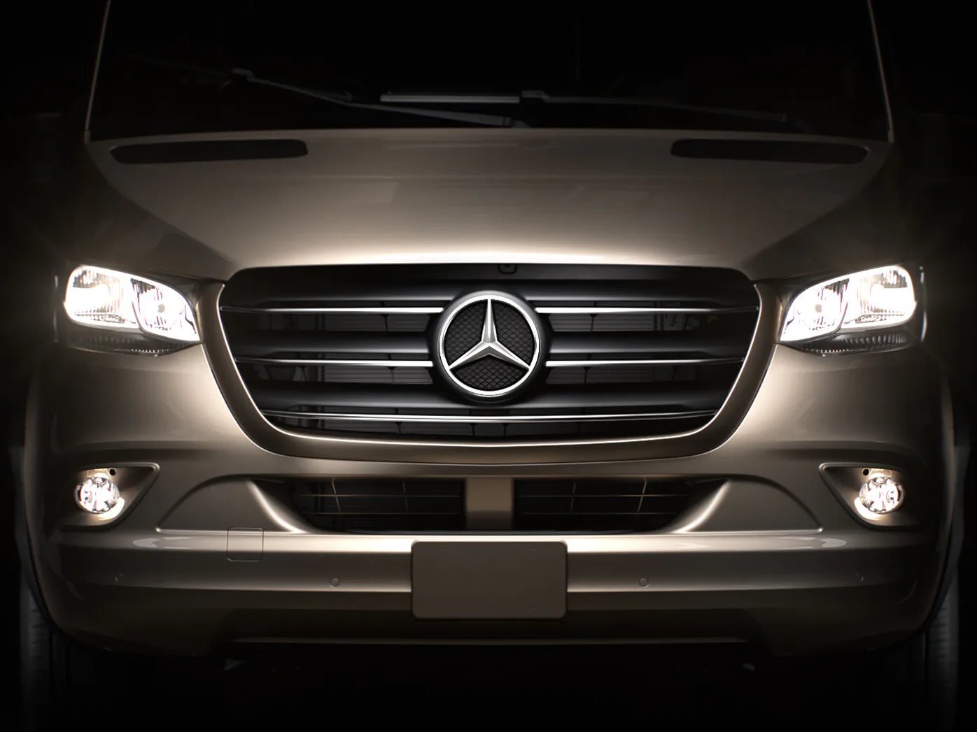 Front des Bürstner Signature Mercedes in Nahaufnahme: Mercedes-Stern im Kühlergrill, eingeschaltete Scheinwerfer, helles Fahrerhaus