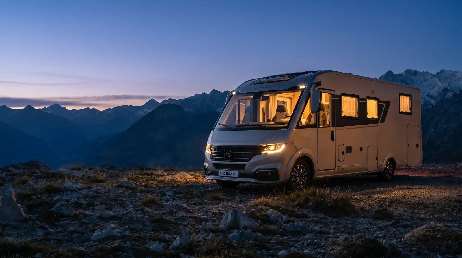 Adria Reisemobil-Liner bei blauer Stunde vor Alpenpanorama