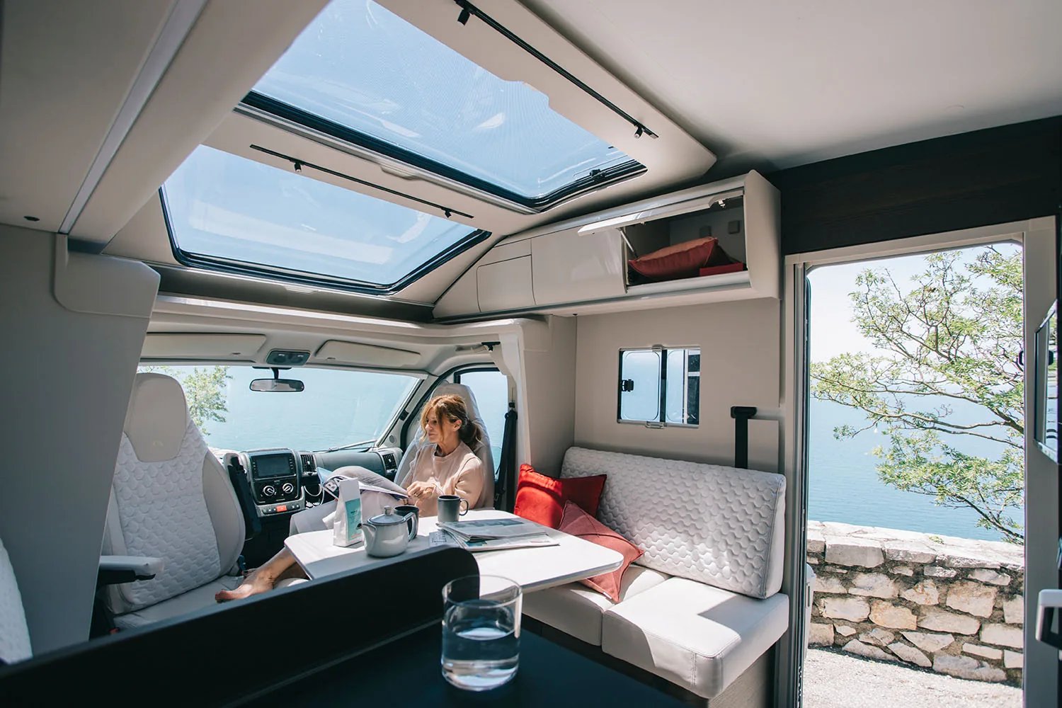 Adria Coral 2026 - offener Wohnraum mit geöffnetem SunRoof und Blick ins Freie am Meer
