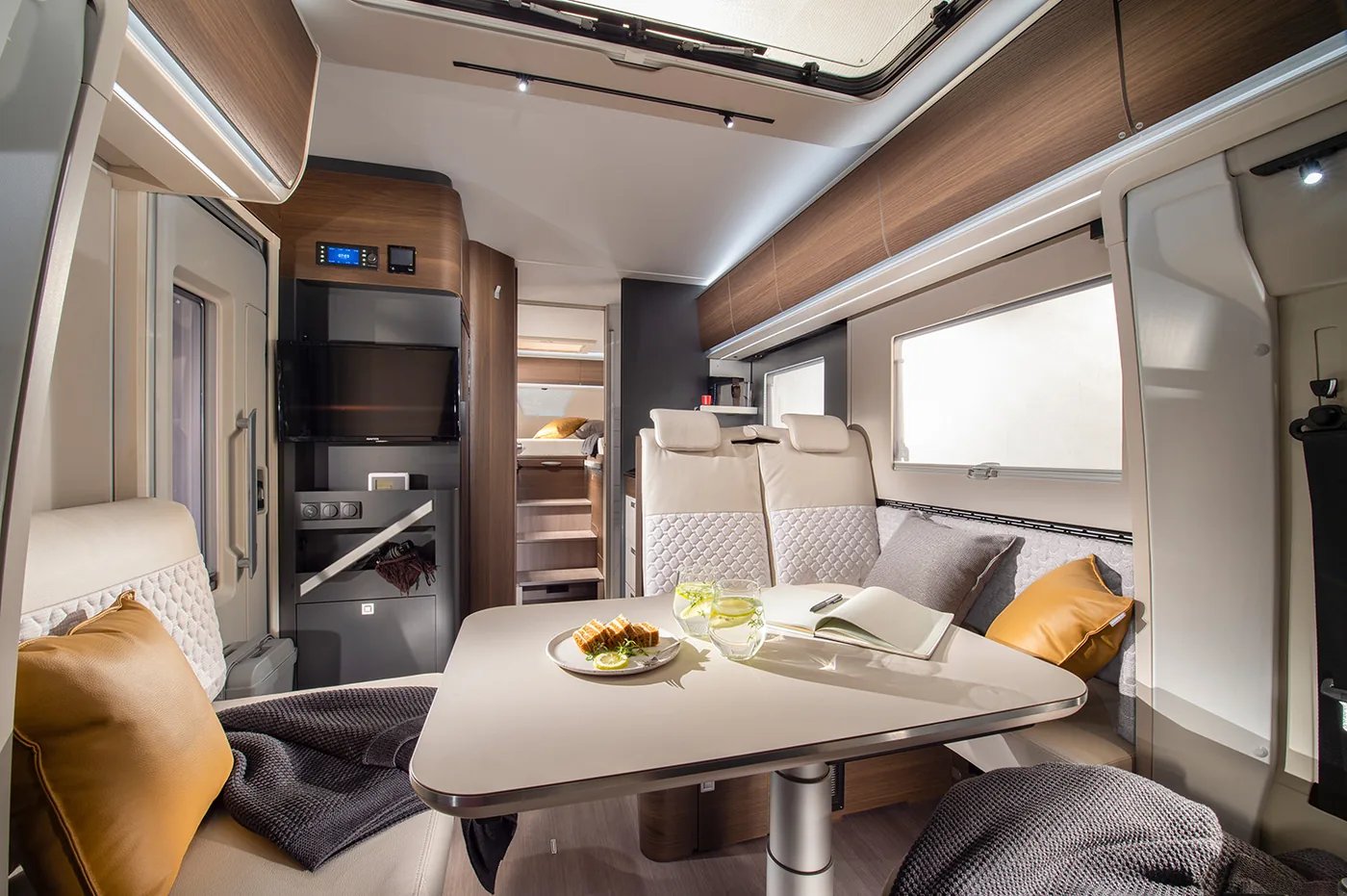 Adria Coral 2026 - offener Wohnraum mit gemütlicher Dinette und Multimedia-Wand