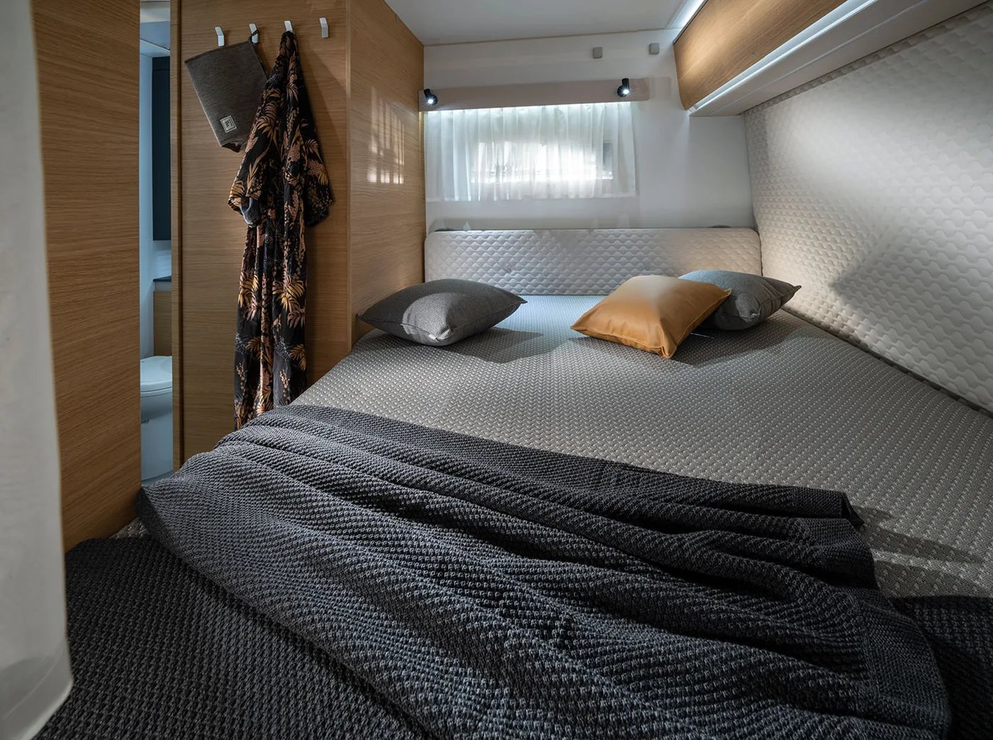 Adria Coral XL 2026 - Schlafbereich im Heck mit Heckbett und Kleiderhaken