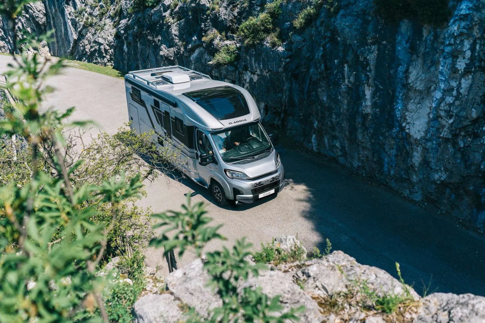 Adria Coral 2026 auf Fiat-Basis aus der Vogelperspektive auf einer Bergstraße, SunRoof im Dach sichtbar