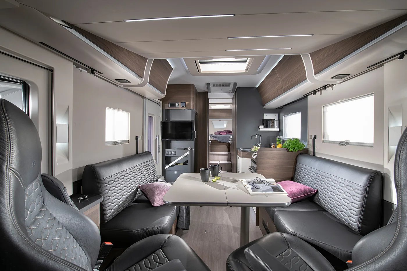 Adria Sonic 2026 - offener Wohnraum mit Dinette, niedriger Trennwand zur Küche und Panoramadachfenster