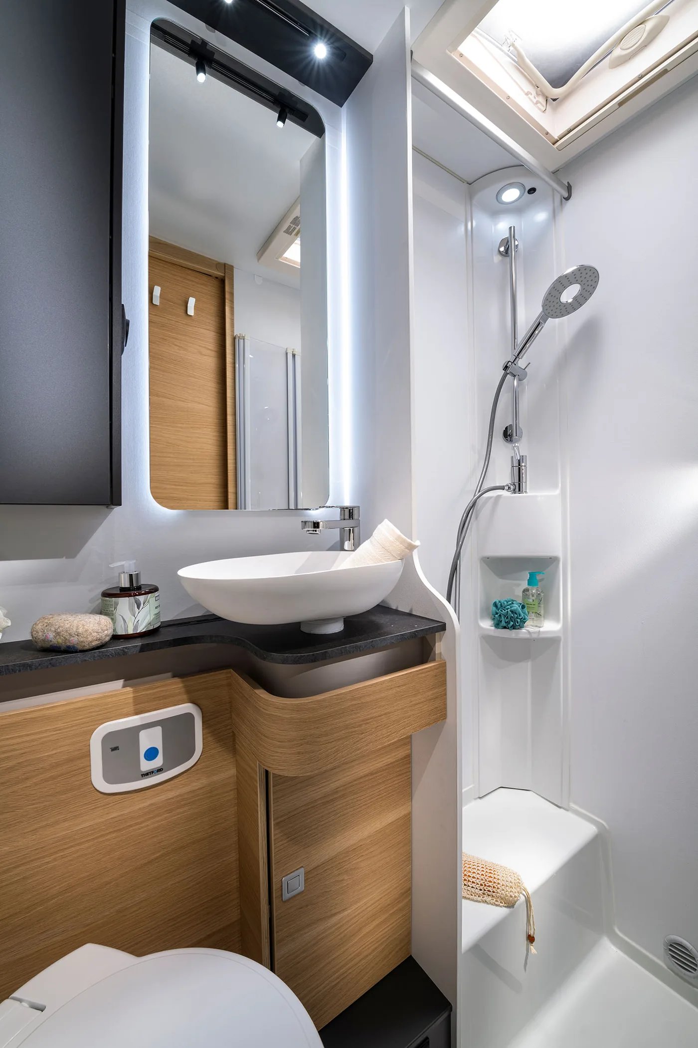 Adria Coral XL 2026 - Badezimmer mit Regendusche und dunkler Fliesenoptik
