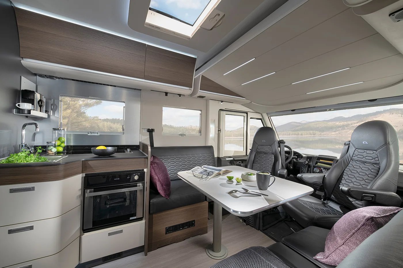 Adria Sonic Supreme 2026 - Wohnraum im dunklen Interieurdesign Moro mit Dinette und Küchenzeile