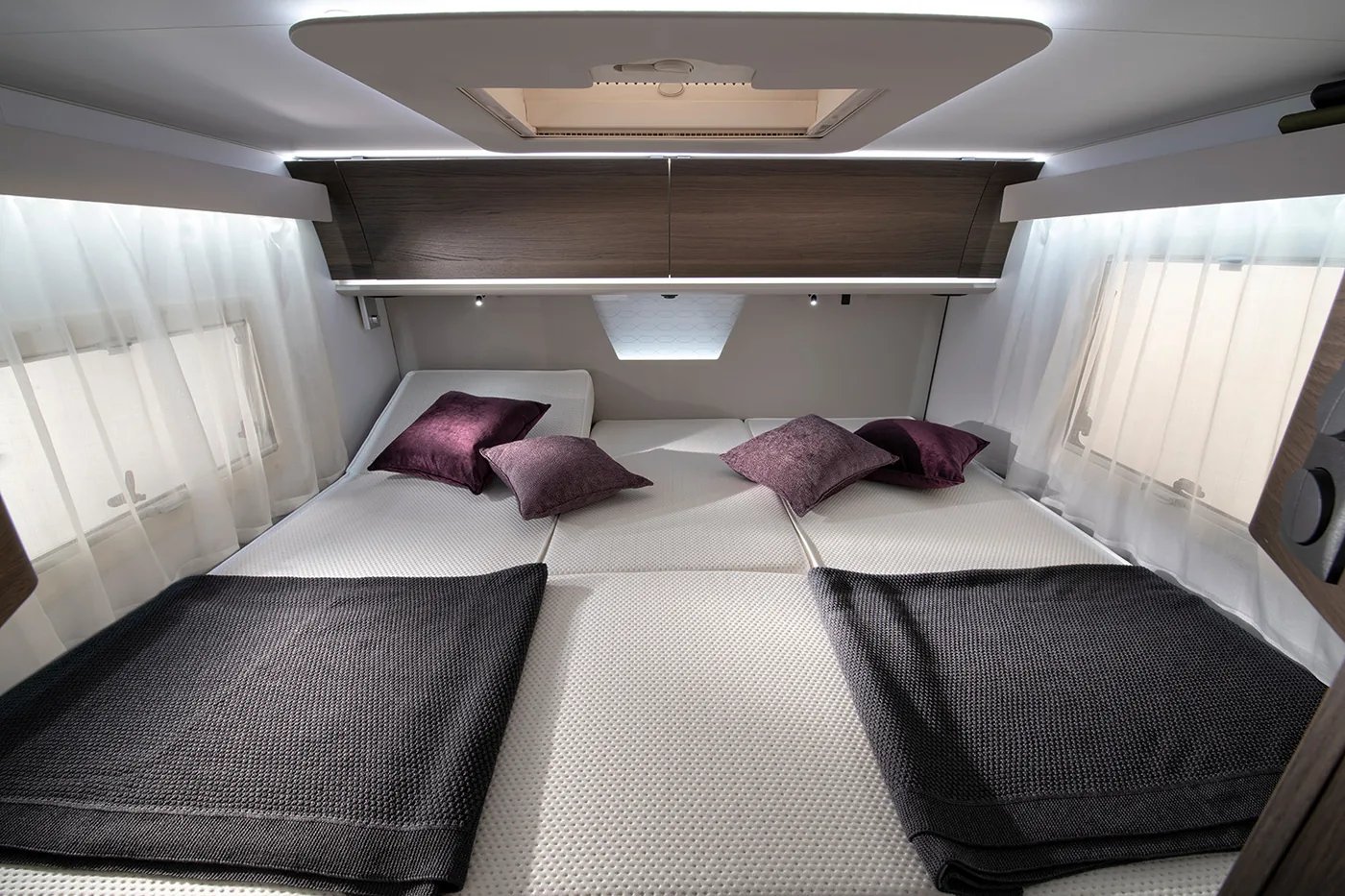 Adria Sonic 2026 - Schlafzimmer im Heck mit zusammengelegten Einzelbetten und Stauraum darüber