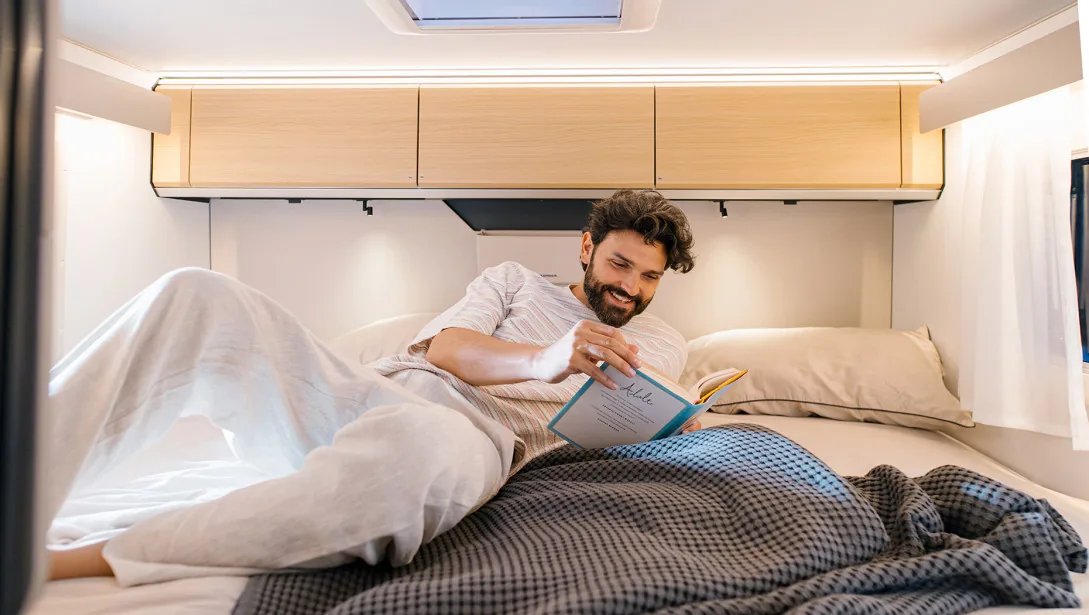 Adria Compact 2027 - Schlafbereich mit Längsbetten und weicher Heckwandpolsterung