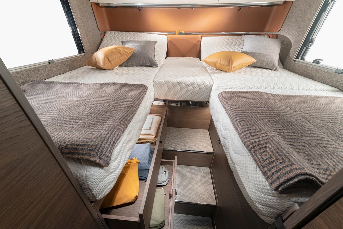 Adria Supersonic 2026 - Bett mit geöffnetem Unterbett-Stauraum und Hängeschrank