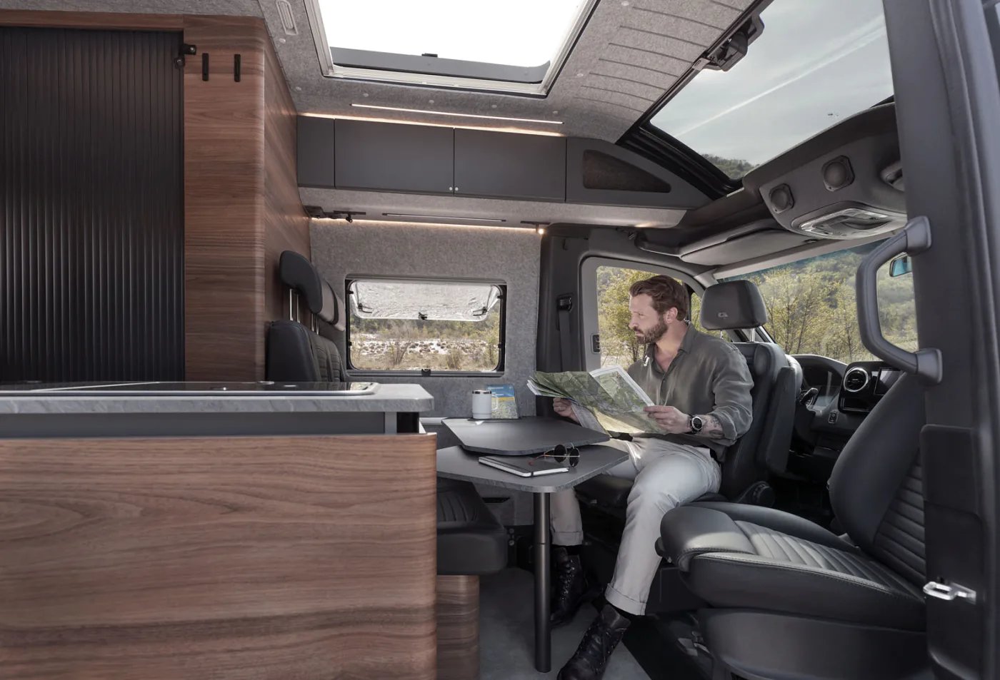 Adria Supertwin 2026 - Wohnbereich mit Dinette, gedrehtem Fahrerhaussitz und geöffnetem Panoramadach