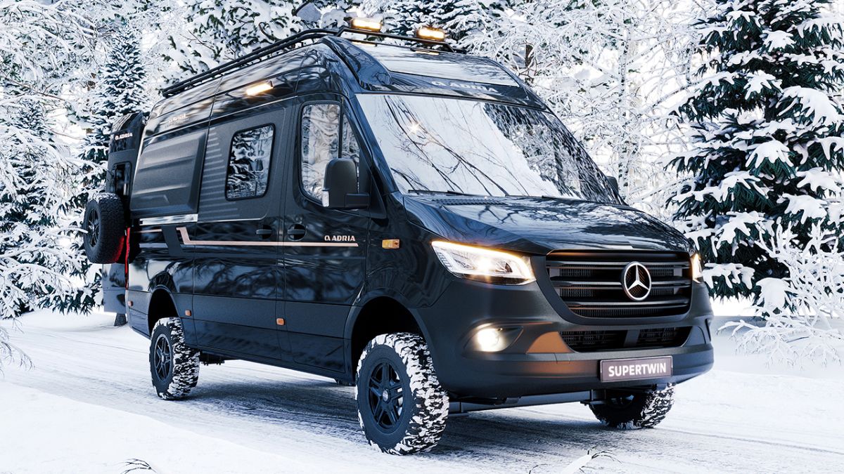 Schwarzer Adria Supertwin 4x4 Kastenwagen auf Mercedes-Sprinter-Basis im verschneiten Winterwald