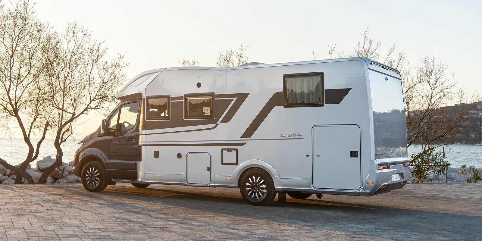 Adria Coral Supreme 2026 auf Mercedes-Benz-Basis in silberner Lackierung, Seiten- und Heckansicht