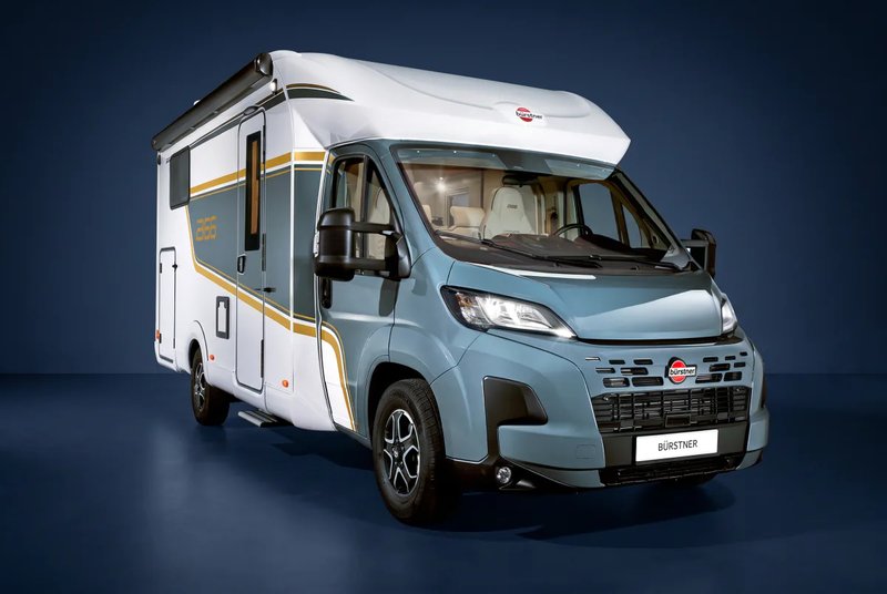 Bürstner B66 Wohnmobil, teilintegriert mit blaugrauem Fahrerhaus und weißem Aufbau, Dreiviertelansicht von vorn rechts vor tiefblauem Studiohintergrund