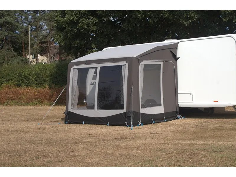 TELTA Pure 260 Vorzelt seitlich an einem Caravan auf grüner Wiese